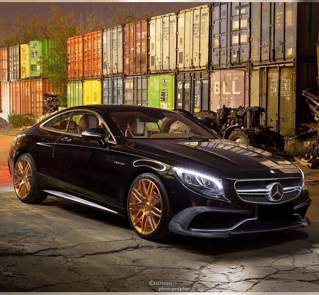 Mercedes-AMG S 63 C217 на старых золотистых дисках, передний ракурс на фоне контейнеров