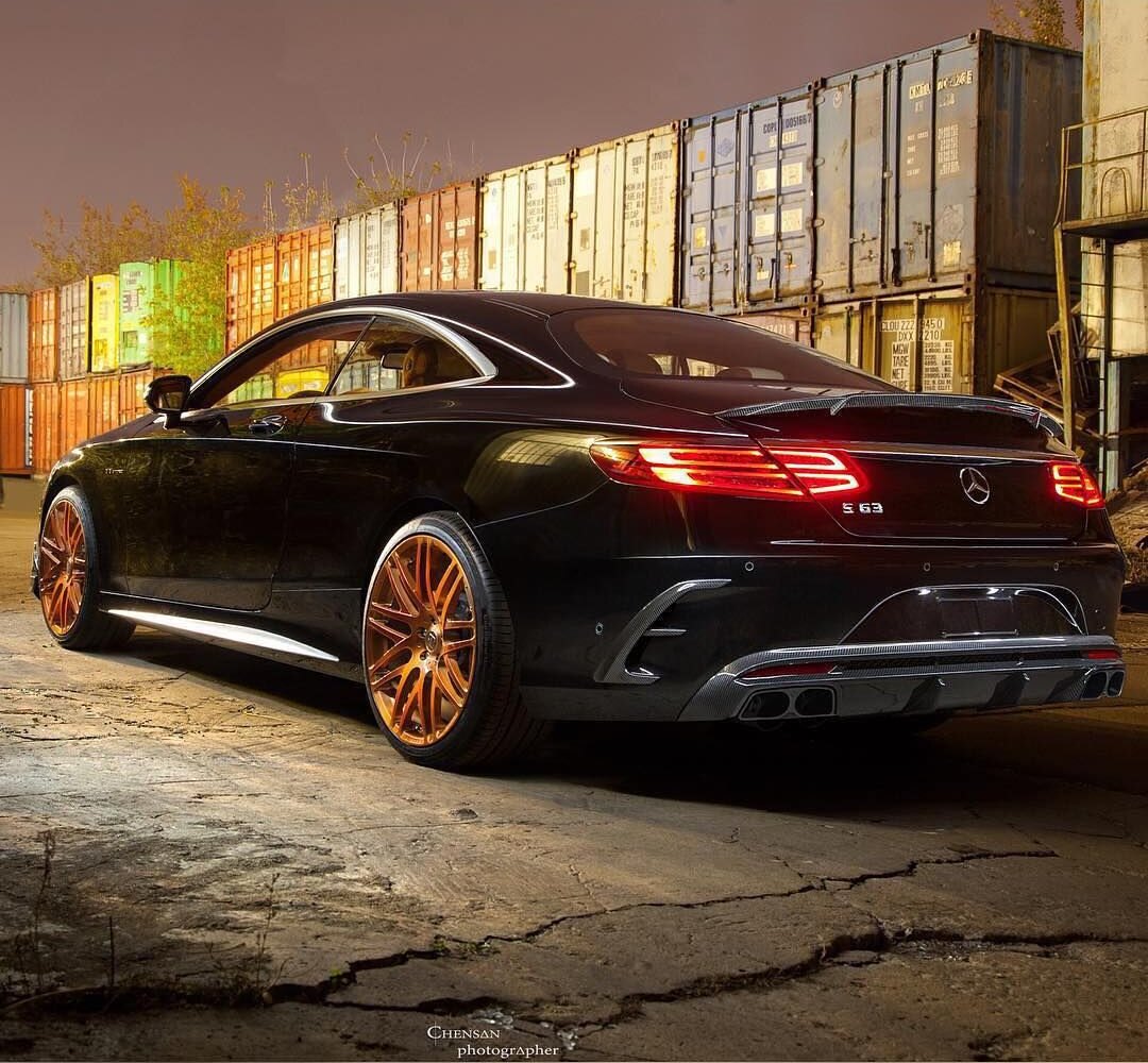 Mercedes-AMG S 63 C217 на старых золотистых дисках, задний ракурс на фоне контейнеров